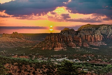 Aerial shot of a canyon in Sedona and a locality under the pink sky at sunset