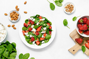Strawberry and spinach fresh salad with cottage cheese and almonds, top view