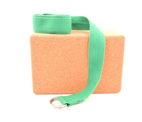 One cork yoga block and green strap isolated on a white background