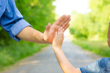 A Hands of a happy parent and child in nature in the travel park