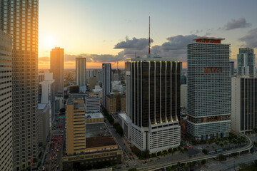 Aerial view of downtown district of of Miami Brickell in Florida, USA at sunset. High skyscraper buildings and street with cars and Metrorail traffic in modern american midtown