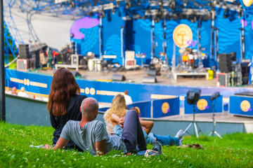 People relaxing on lawn during performance