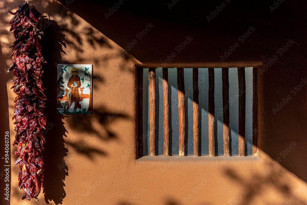 Sticker art piece paint style on an orange sunny wall by a window and a bunch of chilies