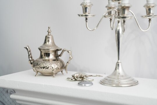 Vintage silver teapot and candle holder on the white drawer chest