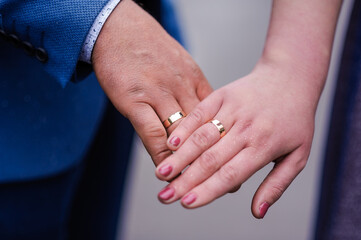 Wedding gold rings on the hands of the newlyweds. Gold rings on the hand of a man and a woman