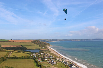 Paraglider flying above Beesands in Devon	