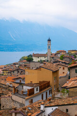 Scenic landscape of Limone sul Garda, captured from La Limonaia del Castel. The colorful buildings, the beautiful Parrocchia di Limone sul Garda and lake Garda in the background