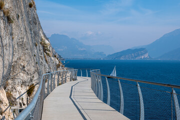 Cycle path in Limone sul Garda near lake Garda in sunny spring day - obrazy, fototapety, plakaty