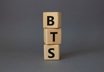 BTS symbol. Wooden cubes with word BTS. Beautiful grey background. BTS concept. Copy space.