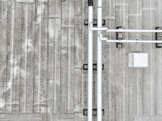 Aerial view of an Industrial looking HVAC equipment and pipes on gray roof.