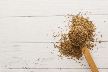 cumin seeds on spoon on table with copy space 