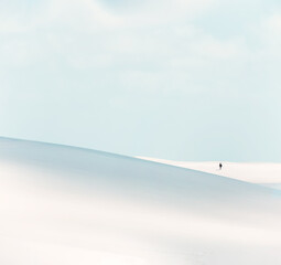 silhouette of a person hiking on the white dunes of Lencois Maranhenses
