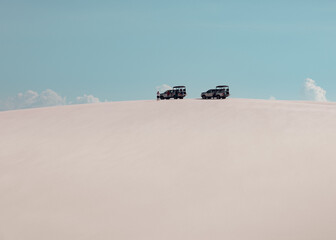 offroad cars on the  white dunes filled with rain water of Lencois Maranhenses