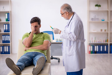 Obraz premium Young male patient visiting old male doctor in vaccination conce