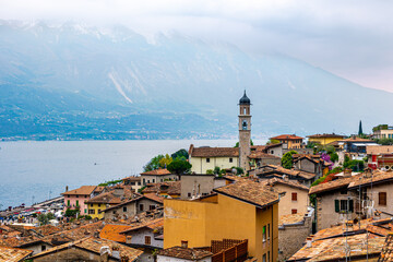 Stunning cityscape of Limone sul Garda captured from La Limonaia del Castel. This picturesque landscape showcases the vibrant colors of the buildings, and the beautiful Parrocchia di Limone sul Garda
