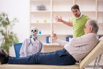 Obraz premium Old male patient visiting skeleton doctor
