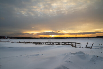 A snowy beach with a sunset in the background