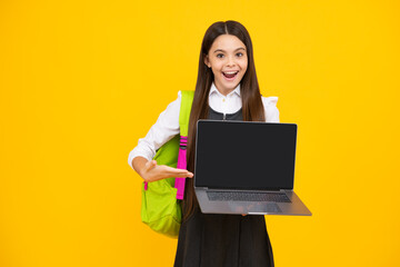 Teen schoolgirl hold laptop on isolated studio background. Cchool student learning online, webinar, video lesson, distance education. Screen of laptop computer with copy space mockup.