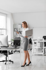 Female accountant with calculator and laptop in office