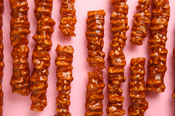 Tasty churchkhela on pink background, closeup