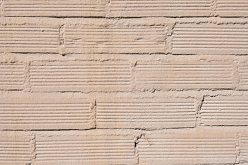 A light colored painted cheap brick wall