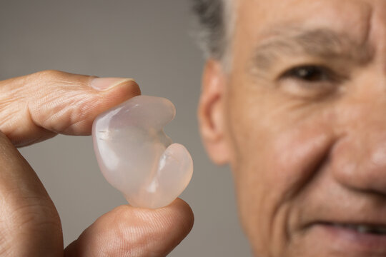 Older Man showing off his custom made silicone earplugs for hearing protection
