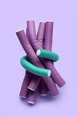 Hair curlers on lilac background