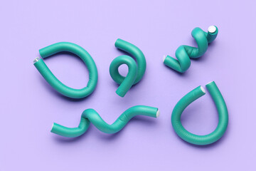 Hair curlers on lilac background