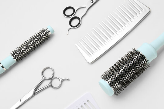 Hair brushes with scissors on light background