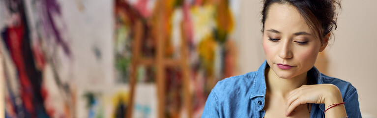 Young woman making chess move while sitting at home and playing chess alone