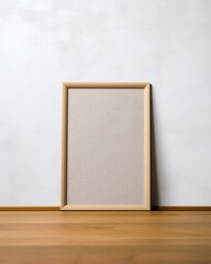 Blank picture frame on the wooden floor in front of white wall