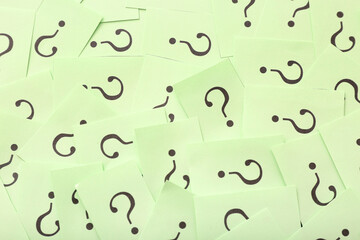 Green papers with question marks as background