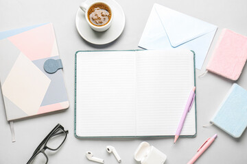 Composition with notebooks, cup of coffee, glasses and earphones on grey background