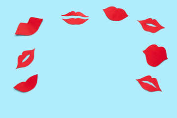 Frame made of red paper lips on blue background