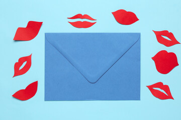 Envelope with red paper lips on blue background