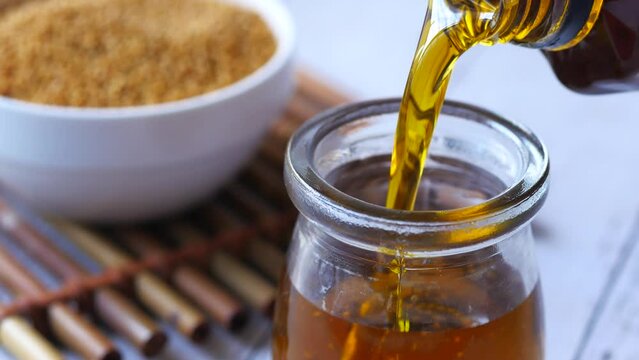 pouring Mustard oil in a jar closeup