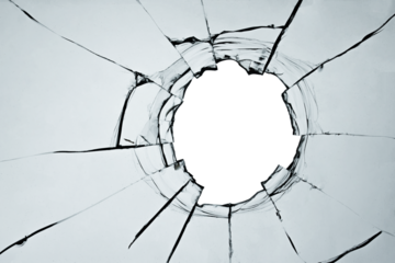Broken window, background of cracked glass with a hole from a shot or smash. Abstract cracked texture with white background in the middle