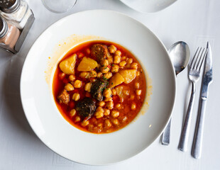 Garbanzos del pastor, spicy soup with chickpea, vegetables and sausages served in a restaurant