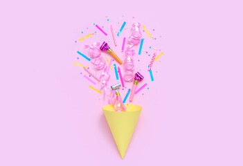 Party cone with confetti and whistles on pink background. Children's Day celebration
