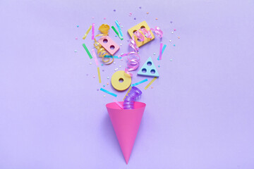 Party cone with baby blocks, confetti and serpentine on lilac background. Children's Day celebration