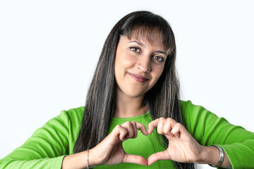 Young woman making a heart with her hands over a white background.