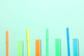 Colorful markers and rulers on blue background