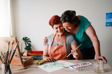 Senior artist gay couple couple painting inside art gallery school - Lesbian family, LGBTQ concept