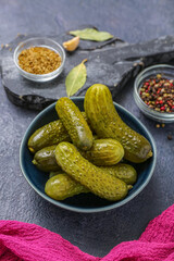 Bowl with tasty fermented cucumbers on dark grunge background