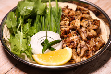 Chicken tikka Dajaj with salad, wedges, lemon and dip served in dish isolated on background top view of arabic food