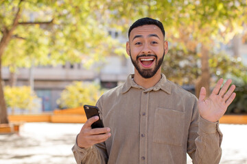 young  adult man feeling happy and astonished at something unbelievable. using a smartphone concept