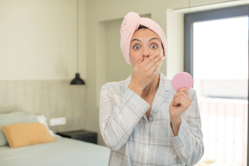young pretty woman covering mouth with a hand and shocked or surprised expression. making up concept