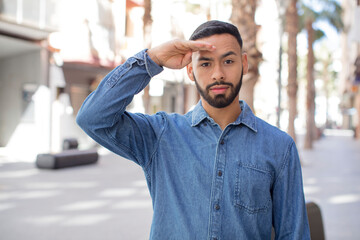Fototapeta premium young handsome man greeting the camera with a military salute in an act of honor and patriotism, showing respect
