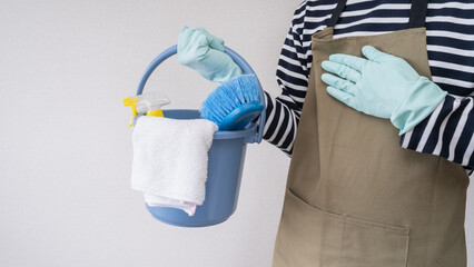 エプロンを着た男性と掃除道具