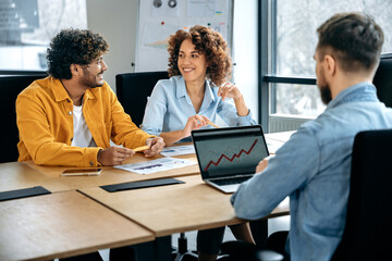 Group work. Successful positive multiracial business people working together in the office, have brainstorm in a meeting room, discuss financial and promotion strategy of a project,smile to each other